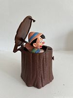 Pop-up toy side view with Pinocchio protruding from open stump