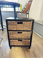 Front view showing three wicker drawers in black frame