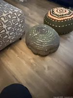 Front view of crocheted floor pouf on wood floor