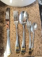 Five assorted Göttinghen flatware pieces laid out: knife, fork, soup spoon, cocktail fork, teaspoon