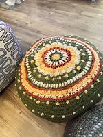 Top view of crocheted floor pouf showing multicolor concentric pattern