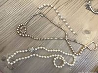 Overall view of two necklaces and bracelet on tabletop