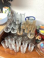 group of various glasses, carafes and shaker on tray, plus pitcher at left edge