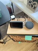 Echo Show 5 display, Nest Mini speaker, cords and adapter on tabletop