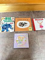 Four children’s books arranged on floor