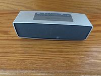 Front view of Bose SoundLink Mini speaker on wooden surface