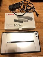 Canon PIXMA iP100 printer closed, LK-62 battery kit box, AC adapter and cord