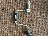 Full view of Fuller hand brace drill showing steel frame, wooden side handle, top knob, and chuck