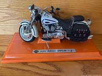 Left front three-quarter view of diecast Harley-Davidson motorcycle on orange stand