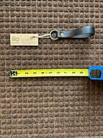 Full view of key ring with tag and tape measure showing roughly 5.5-inch length
