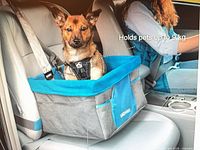 Marketing image on box showing grey and blue Kurgo booster seat holding a small dog, text indicates holds pets up to 9 kg