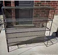 Front view of black metal mesh shelf unit showing full dimensions and shelf levels