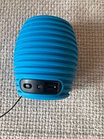 Blue ribbed mini speaker front view showing power switch and micro-USB port