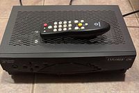 Cable box top view with remote placed on grill