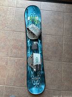 Full view of snowboard showing bindings and deck graphics