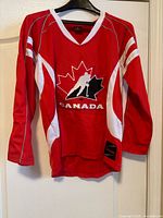 Front view of red Team Canada jersey on hanger