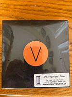 Front of unopened VIE Vaporizer box with orange V logo and silver variant label