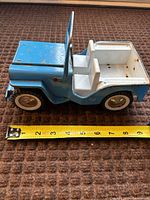 Side view of blue and white Tonka Jeep with tape measure showing length