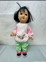 Front view of porcelain doll showing hair, face, and full outfit