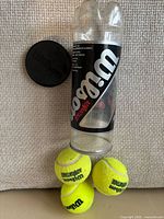 Canister, lid, and three tennis balls overview