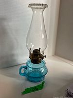 Full view of teal blue finger lamp with chimney