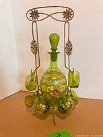 Full view of decanter, stopper, six glasses on metal stand