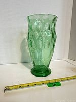 Full view of green uranium glass vase on white background