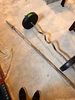 Straight barbell and EZ curl bar with plates on concrete floor
