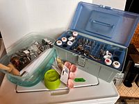Overview of lot showing tool box with icing tips and color jars, tub of cookie cutters, rolling pin, silicone molds