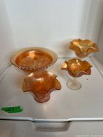 All four carnival glass pieces grouped together in light box