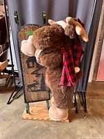 Side view of plush moose against sled showing materials and size