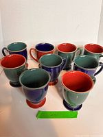 Group of nine Denby speckled stoneware mugs showing color variations
