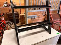 Front angle of black metal two-tier dumbbell rack on tabletop