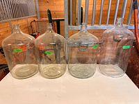 Four glass carboys on table, front view