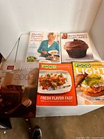 All five cookbooks laid out on table