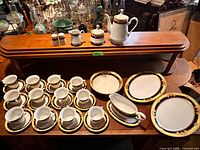 Full set showing teacups, saucers, platters, gravy boat, teapot, salt & pepper