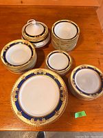 Stacked plates, bowls and lidded tureen showing pattern and quantity