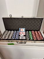 Open camo case showing full set of chips, cards and dealer button