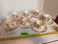 All seven cup and saucer sets displayed