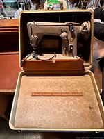 Front view of Singer sewing machine inside open carrying case