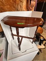 Top and legs of half-round wood side table on white backdrop