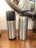 Both stainless insulated containers standing side by side