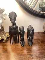 All three carved wood pieces standing on table