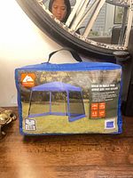 Front of blue carry bag showing brand logo and product illustration