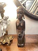 Full view of carved wooden female figurine on tabletop