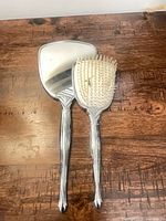 Hand mirror and hairbrush full view on tabletop