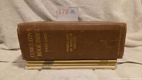 Stacked view of all four books showing spines: brown hardcover "Cumulative Book Index 1933-1937" and three tan "Chronicles" volumes