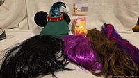 Group view: green Disney felt ear hat, black wig, fuchsia wig, brown wig with streaks