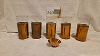 five copper-sleeved glass tumblers and small copper bowl front view