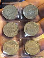 Front view of six coins in clear holder showing mix of obverse and reverse sides